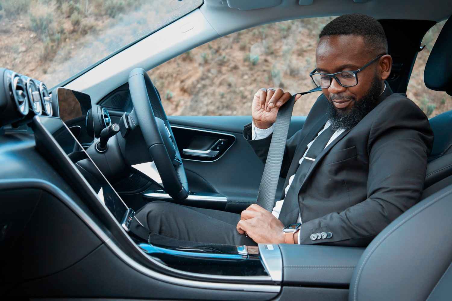 Mercedes-Benz driver securing seat belt in premium luxury sedan interior